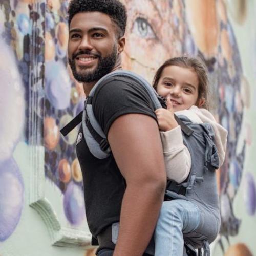 papa porteando en la espalda a una ni&ntilde;a de 4 a&ntilde;os en la mochila porteo Quokkababy
